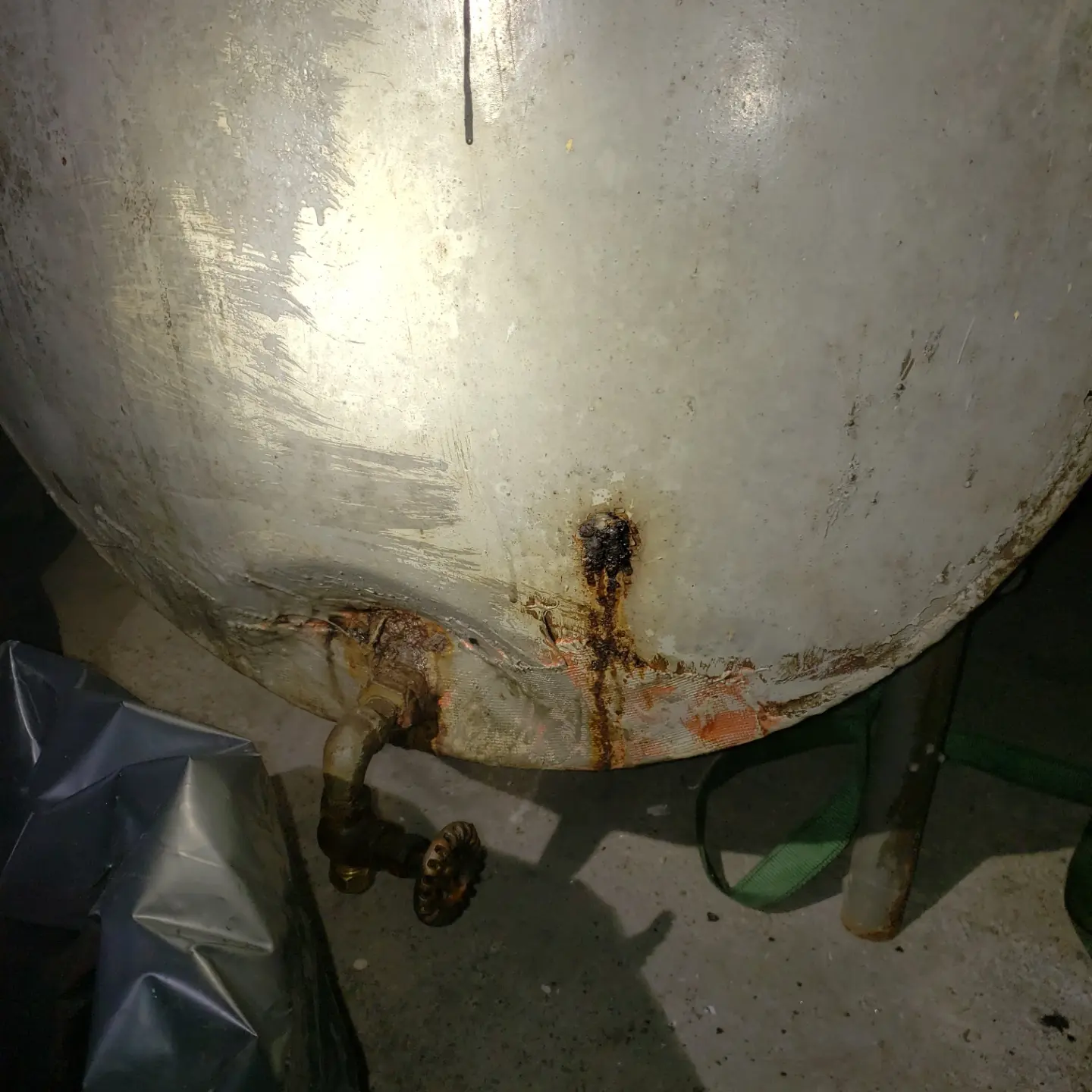 Old corroded leaking oil tank with rust and corrosion at the base