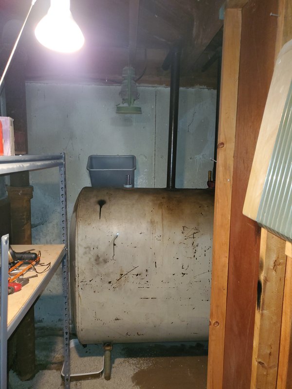 Old steel oil tank in a basement before removal