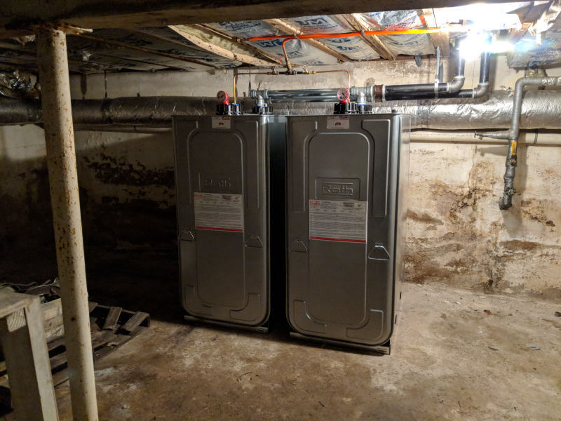 Roth double-wall tanks with labels visible, installed in older Long Island basement
